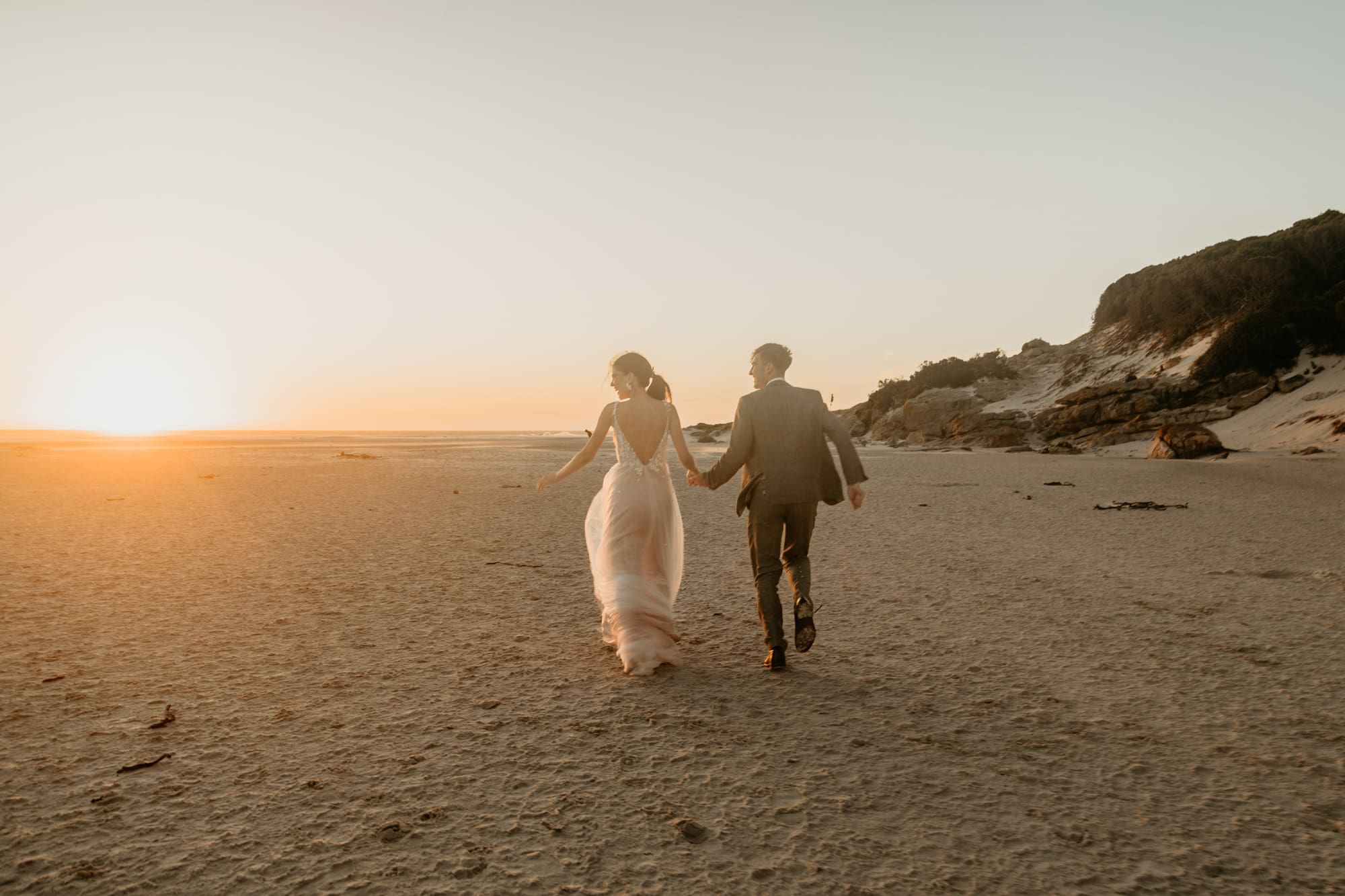 Hochzeitspaar in Kapstadt laufen über den Strand